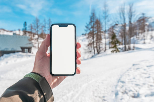 istock Smartphone mockup, man holding mobile phone with blank white screen as copy space in winter tourist resort 1738599847