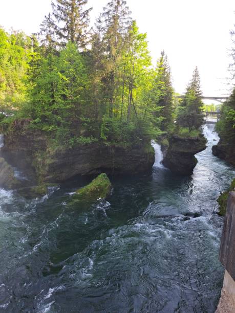istock a stream of water flows between two large rocks with trees in the background 1738599886
