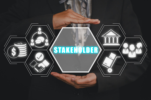 Stakeholder concept, Business woman hand holding stakeholder icon on virtual screen.