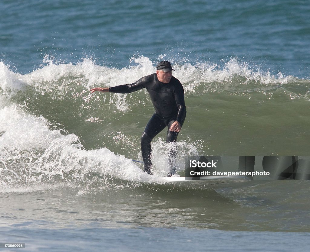Surfer working the waves at Bolsa Chica "Surfer still enjoying the sport at 67 years old, staying young" Surfing Stock Photo