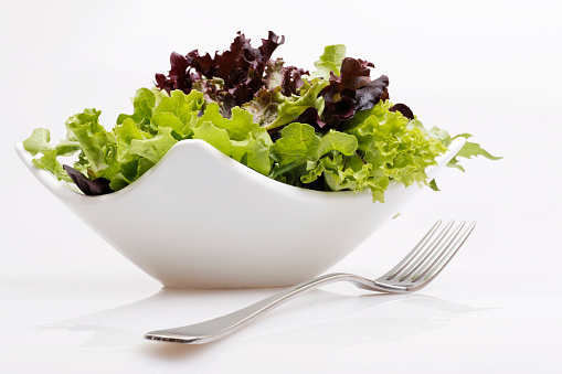 Fresh green leaf salad in a bowl and a fork