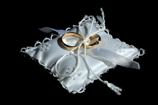 Wedding time - two wedding rings delicately laid on a cushionSee also: