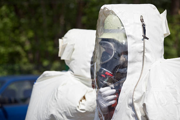 dois homens em equipamento de proteção - radiation protection suit toxic waste protective suit cleaning - fotografias e filmes do acervo