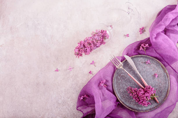 istock Table setting with drinking glass full of lilac flowers 1738618853