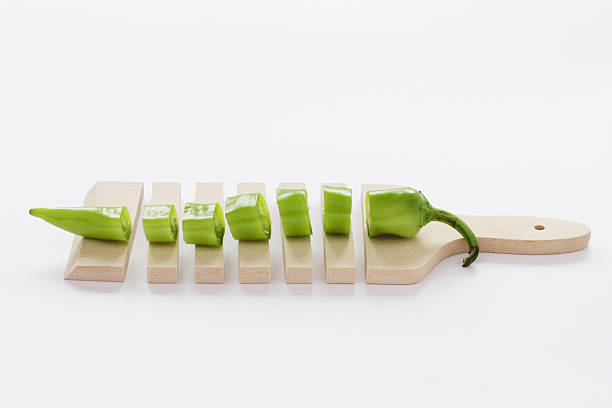 sliced cutting board with green pepper stock photo