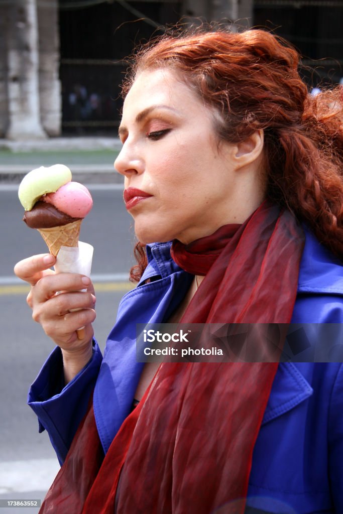 eating icecream woman enjoying some icecream in front of the Colosseum in Rome Adult Stock Photo