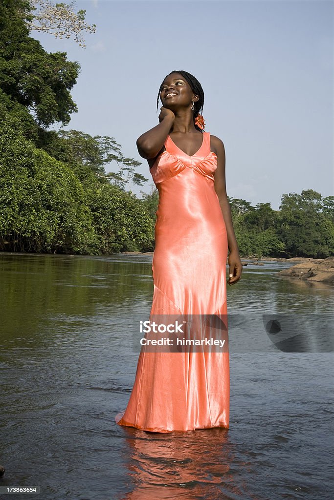 River Beauty A beautiful African woman standing in a river with the jungle in the background. Liberia Stock Photo