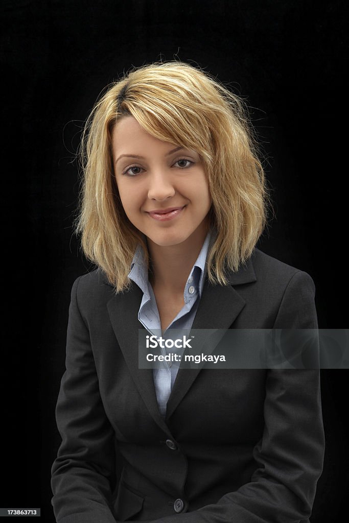 Smiling Businesswoman Portrait Portrait of smiling young businesswoman on black background. Adult Stock Photo