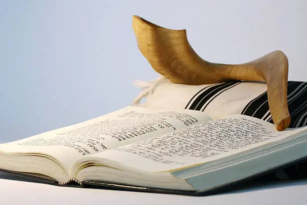 "Religious Judaic objects used for prayer - a shofar, tallis, and prayer book."