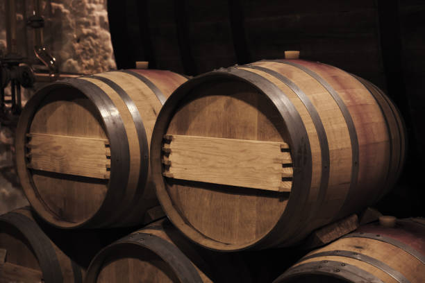 istock Oak wood barrels in dark winery interior, close up 1738641075