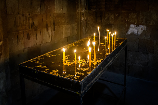 Noravank, Yerevan area, Armenia - 5 January, 2023: Funeral candles in memory of the deceased, lit by parishioners of the ancient monastery, which is still active today.