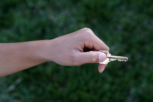 boy's hand holding key as if about to use it to open a door