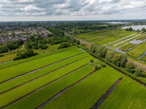 Aerial view towards Gouda Goverwelle from the farm lands with the train track and Reeuwijkse plassen in the background