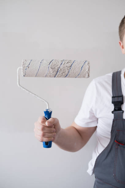 istock A man in overalls holds a wall paint roller in his hands 1738687942
