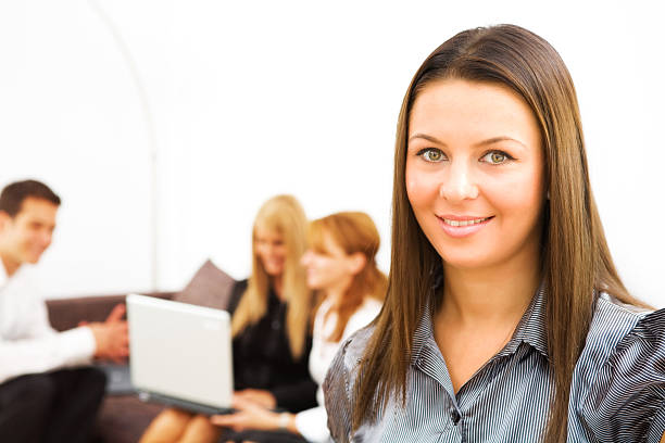 Portret of young business woman (collegues working in the background) stock photo