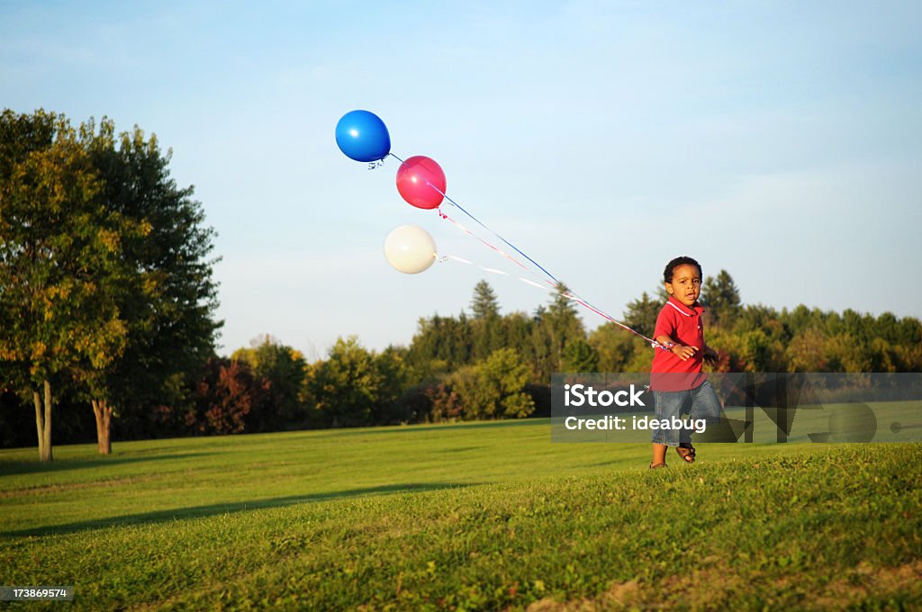 Szczęśliwy Mały chłopiec działa z balonów, poza - Zbiór zdjęć royalty-free (Balon)