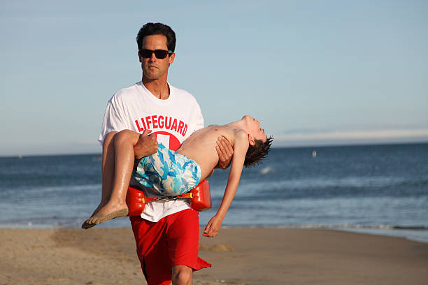 beach ratownik doraźnego - rescue child carrying physical injury zdjęcia i obrazy z banku zdjęć