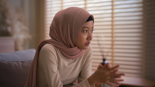 Muslim woman wearing hijab sitting stressed and depressed