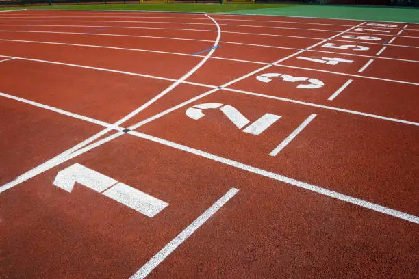 Close-up of the starting line of track running lanes in a sport stadium with numbers. Life is a competition like sports.