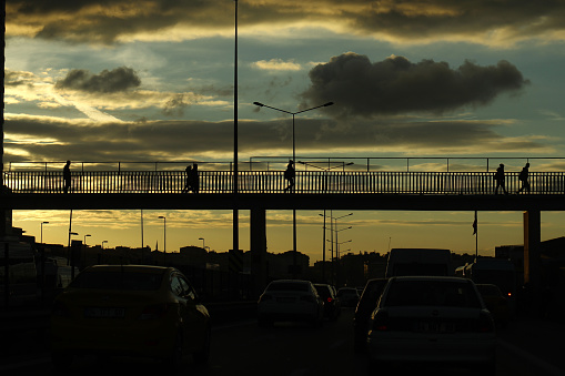 Silhouettes of people crossing overpass in Istanbul