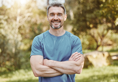 Senior, fitness and portrait of man with arms crossed in a park happy with workout, running or results. Exercise, face and elderly male runner smile in forest for training, workout or body challenge
