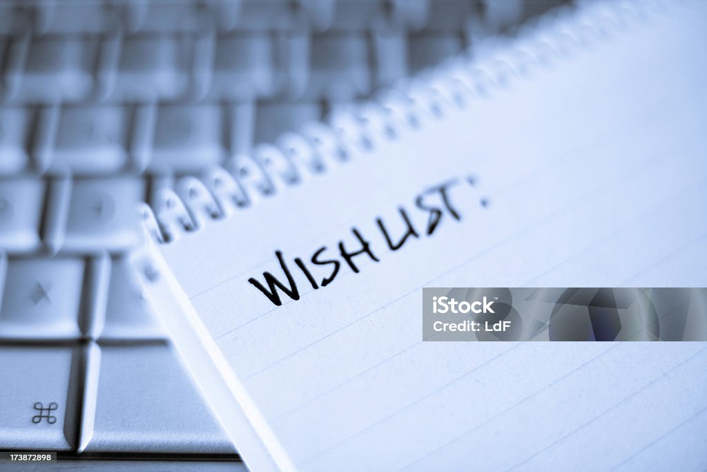 Cuaderno con espiral en la computadora portátil con Wishlist blanco - Foto de stock de Lista de deseos libre de derechos