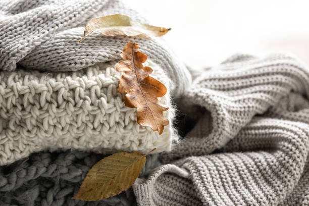 istock Close-up of a stack of knitted sweaters with autumn leaves. 1738734034
