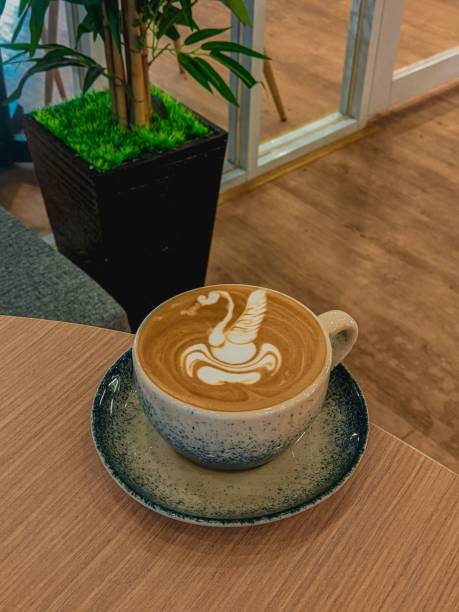 istock a cup of coffee is next to a plant on a table 1738736231