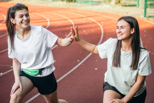 istock Young women doing stretching exercises at the stadium. 1738737729
