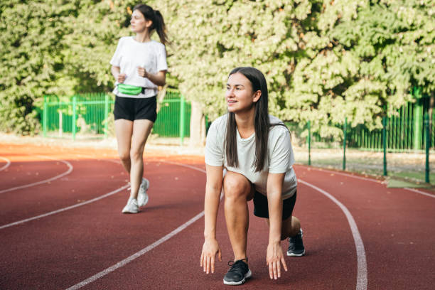 istock A young woman runner in start position on running track while work out. 1738737883