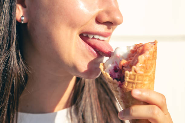 istock Close-up female lips eating a ice cream cone. 1738741964