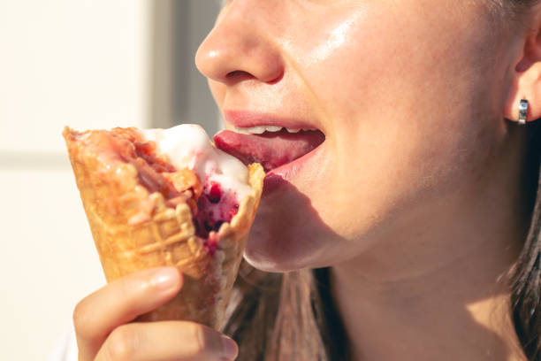 istock Close-up female lips eating a ice cream cone. 1738741967