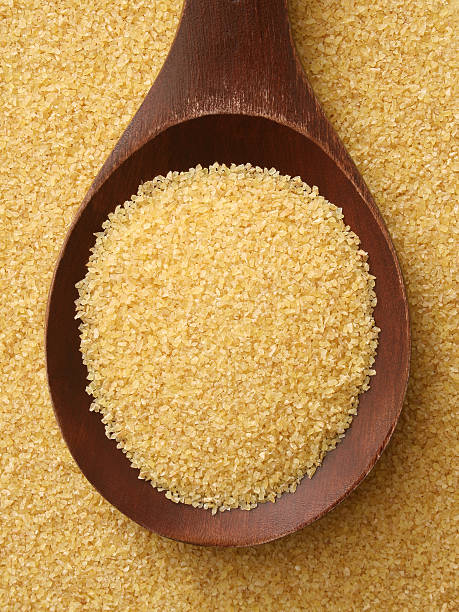 Semolina wheat Top view of wooden spoon full of semolina wheat used to prepare couscous couscous stock pictures, royalty-free photos & images