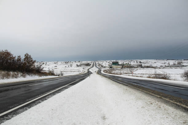 istock Snow-covered long road, rural area, asphalt road 1738750027