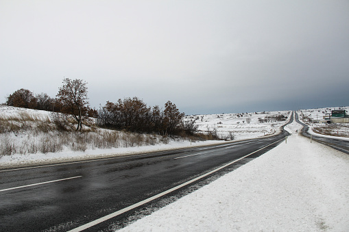 Snow-covered long road, rural area, asphalt road