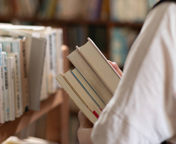 avoir un livre - stacking bookstore reading book photos et images de collection