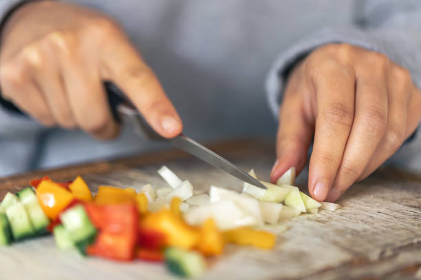 istock A woman cuts vegetables on a cutting board. 1738762255