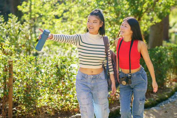 istock Cheerful Asian women walking in forest together 1738763922