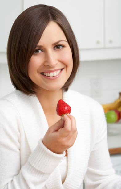 istock Young Woman Eating a Strawberry 173876884