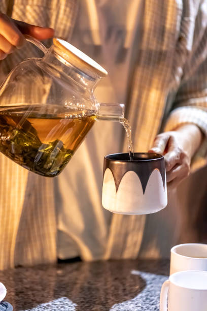 istock A woman pours tea into a cup late at night. 1738773847