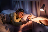 Teenage girl checking time in smartphone at night