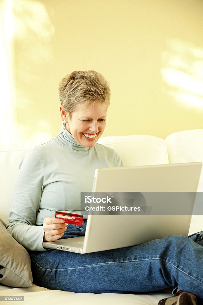 Atrakcyjne Starsza kobieta zakupy Internet na laptopie - Zbiór zdjęć royalty-free (60-64 lata)