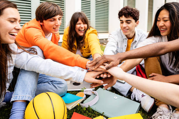 Multiracial group of young student people stacking hands at college campus