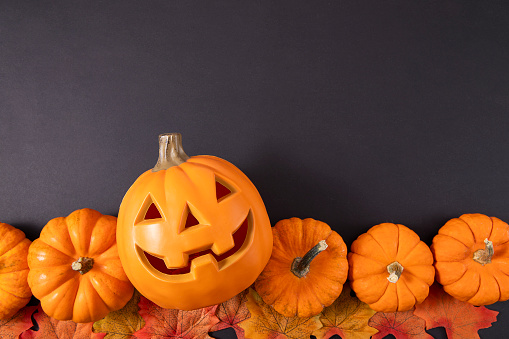 Halloween decorations, pumpkinson orange background with copy space