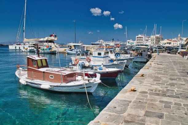 istock Tranquil coastal harbor with several small boats moored near a stone pier, surrounded by blue waters 1738796034