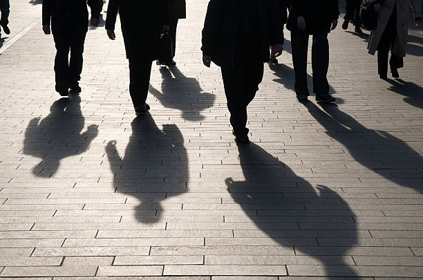 istock Shadow Team of Commuters Walking on Smooth Stone Walkway 173879654