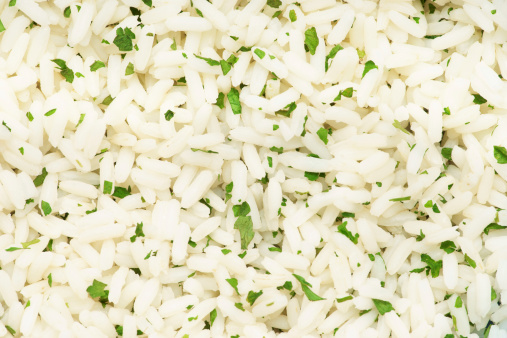 Cooked rice with parsley as background