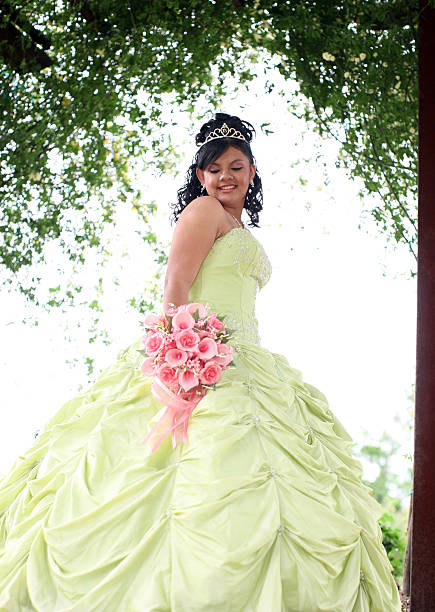 Beautiful Quinceanera Young teen wearing a quinceanera dress on her 15th birthday. quinceanera stock pictures, royalty-free photos & images