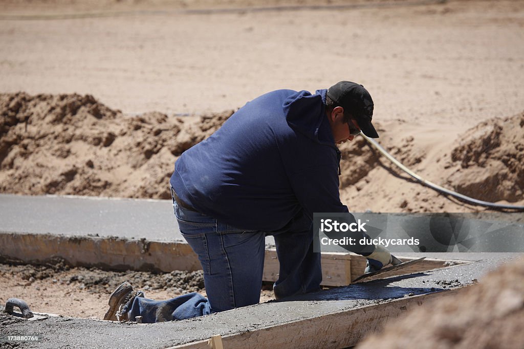 Homme lissant ciment sur le Site de l'emploi - Photo de Béton libre de droits