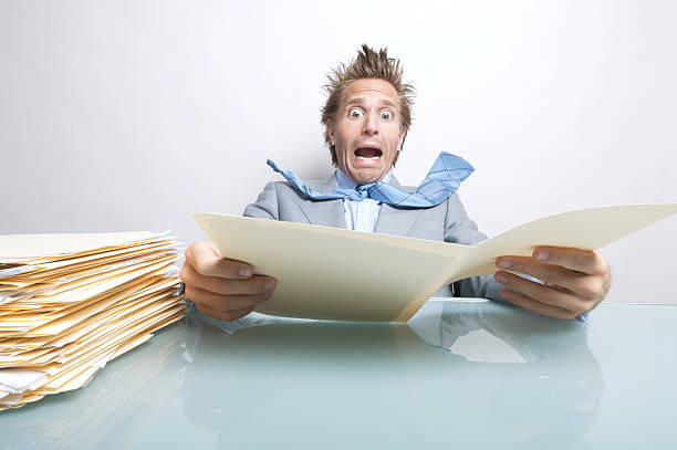 istock Surprised Businessman Office Worker Opening Stressful File Folder at Desk 173880825